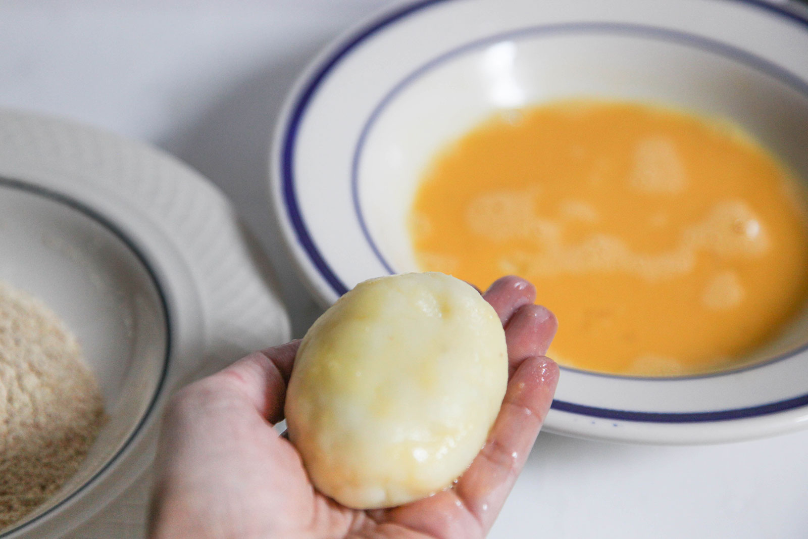 Dipping croquette in egg for making Perfect Potato Croquettes (Bangladeshi Alu Chops)