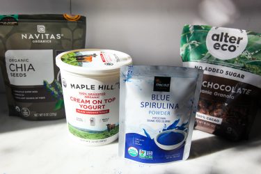 Packaged ingredients including chia seeds, yoghurt, blue spirulina powder, granola