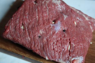 Cloves and garlic cloves inserted into beef, prior to brining