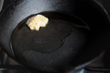 Heating ghee for cooking Golden Yellow Dal (Lentil Soup) with Turmeric, Garlic, Cilantro