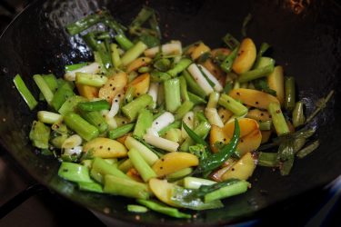 previously fried potatoes added back to wok with green garlic