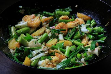Green Garlic Sautéed with Shrimp, Potatoes & Grated Coconut, cooked in a wok