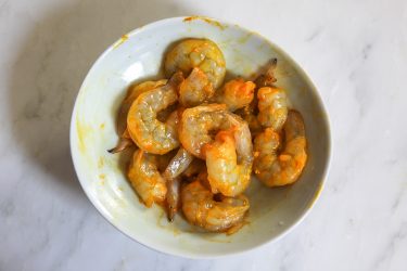 shrimp dusted with turmeric & salt marinating in a bowl (to be used for green garlic dish)
