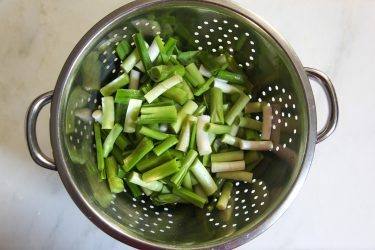 Green garlic in a colander, rinsed and cut into 1-inch pieces