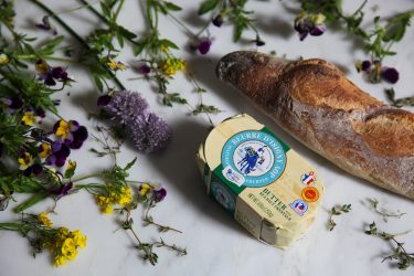 ingredients including butter, edible flowers, chive blossoms and stalks, and a baguette