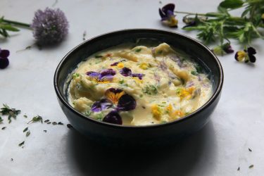 Herb butter with edible flowers in a bowl, ready to serve