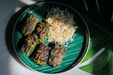 Cooked paturi parcels on a plate with rice