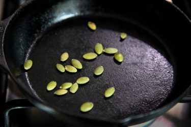 Toasting pumpkin seeds on a pan