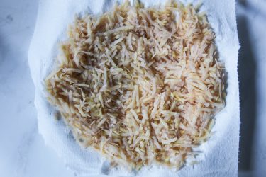 Shredded potatoes drying on paper towel