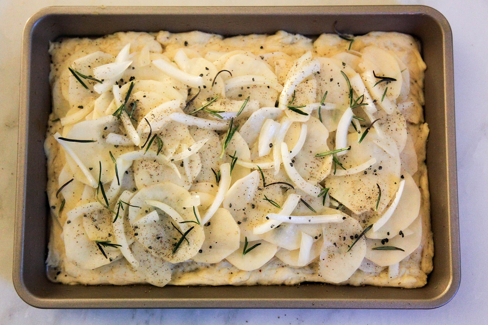 potato & onion slices, layered with rosemary and sea salt on dough base