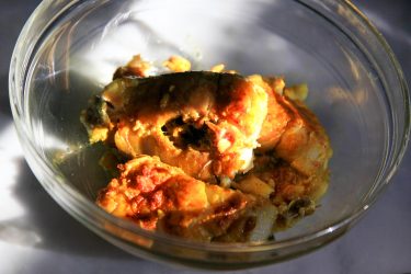 cleaned and dried fish pieces rubbed with spices and marinating in a bowl
