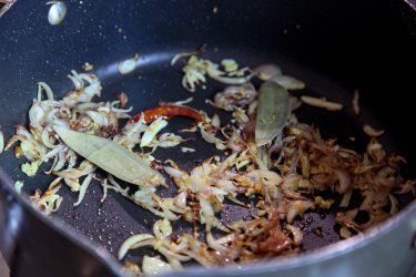 Bay leaves and whole dried red chili added to sauteed shallots, ginger, garlic