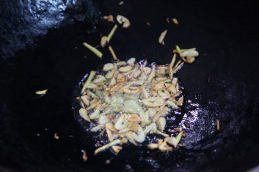 Garlic and ginger stir-fried in a wok until browned