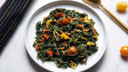 Sukuma Wiki of Sautéed Kale with Tomatoes, Garlic & Ginger served on a plate and ready to eat