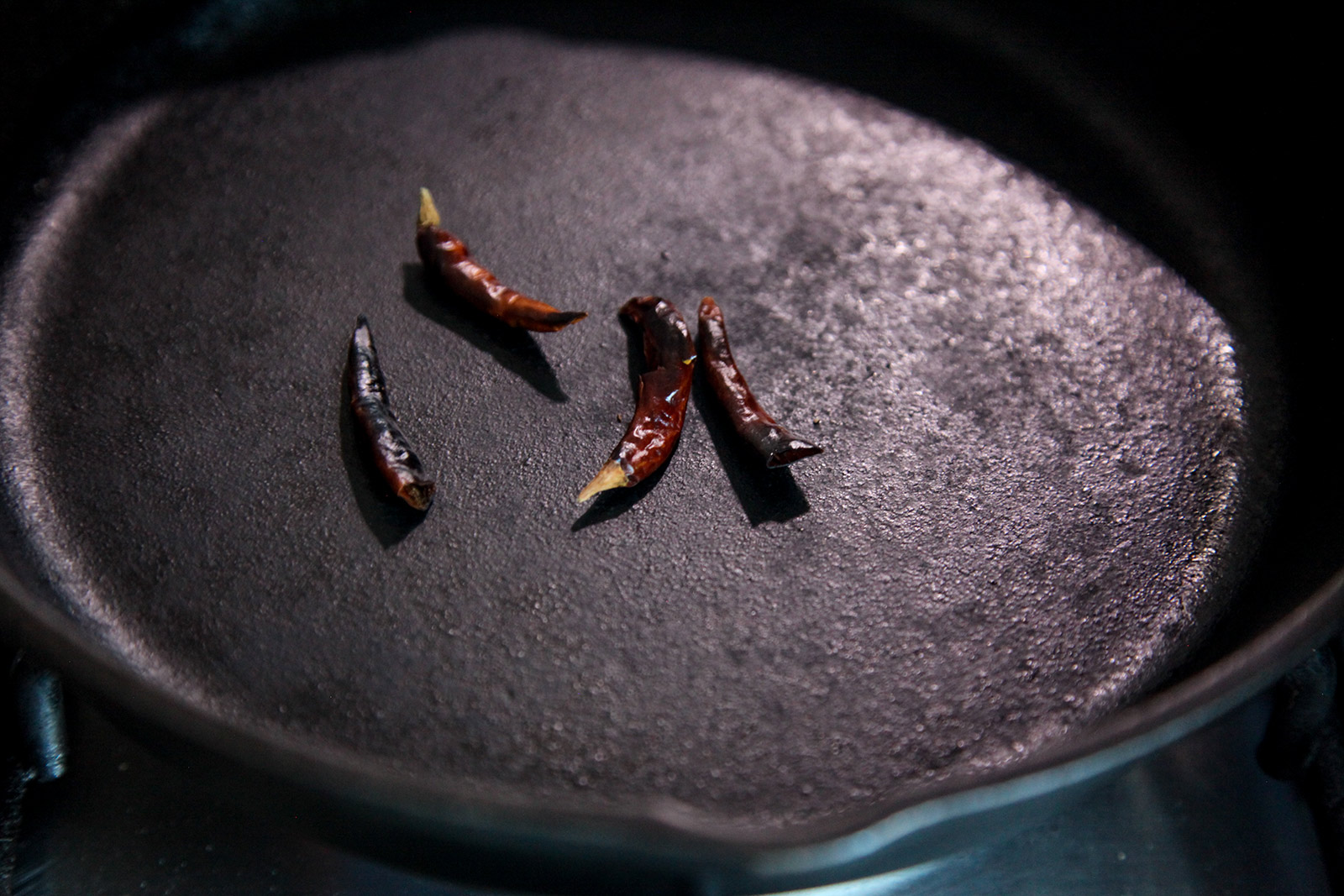 Charring dried red chilies on a pan on dry heat