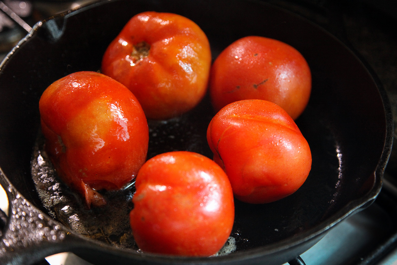 Tomatoes cooking in a little oil in a pan