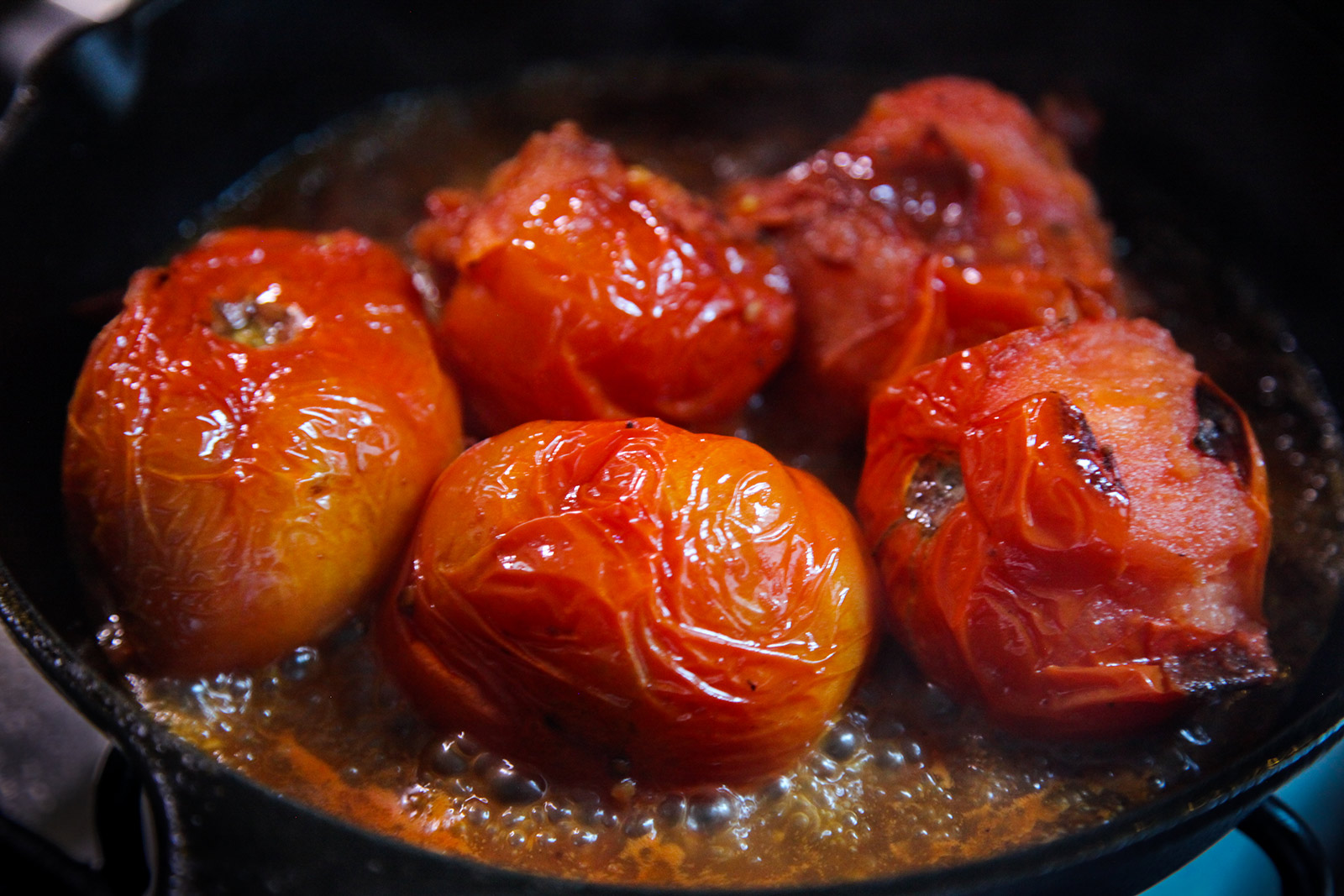 Tomatoes starting to disintegrate as they cook in a pan